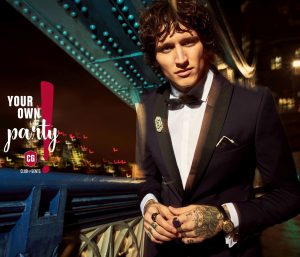 pan młody w granatowym garniturze smokingowym, w białej koszuli, w muszce